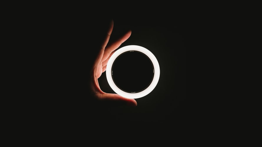 A hand holding a glowing ring.