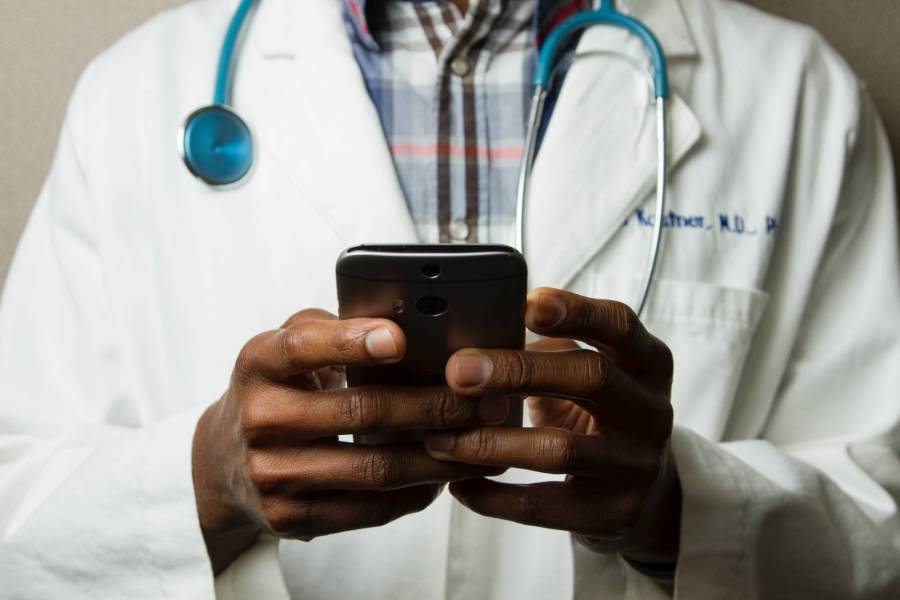 A doctor checking his patient's status on his smart phone.