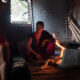Divya, 20, prepares a meal at her home amid the searing heat