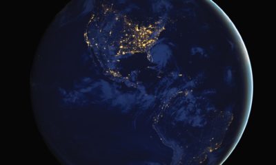 a satellite view of Earth on the hemisphere away from the sun with city lights visible